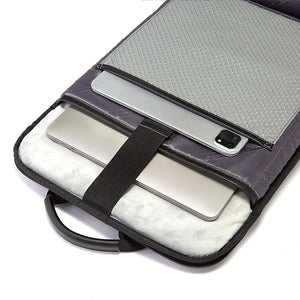 Black interior laptop compartment with elastic bands holding phone and tablet; zipper closure