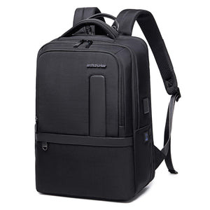 Black waterproof travel backpack with top handle, front pocket, and side attachment loop