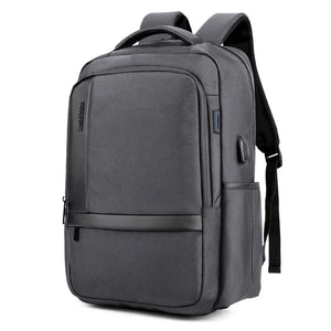 Large capacity waterproof travel backpack with front zip pockets, in grey fabric.