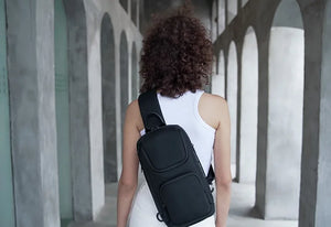 Compact waterproof crossbody bag in black, worn from back with shoulder strap