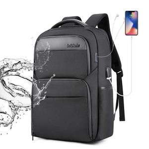Black travel backpack with front zip pockets, padded front panel, and side USB cable