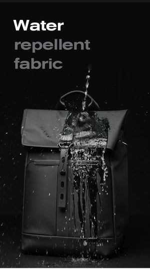 Black waterproof travel backpack front with water-repellent fabric and heavy water splash.
