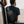 Black crossbody sling bag worn on back with compact front pocket and adjustable strap