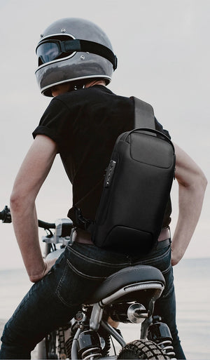 Black sling bag worn across back with front pocket and adjustable shoulder strap