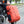 Orange travel backpack carried on shoulder with side straps and front zip pocket