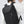 Black backpack worn on back with front zipper pocket and padded shoulder straps