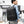 Black computer travel backpack worn on shoulder with side handle and front pocket.