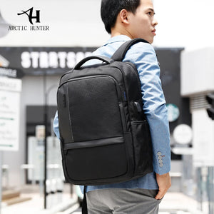 Black computer travel backpack worn on shoulder with side handle and front pocket.