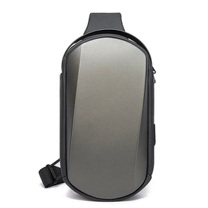 Grey compact crossbody sling bag with curved front panel and side zippers