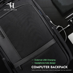 Black backpack with external USB charging port and built-in headphone wire routing.
