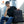 Black business backpack carried with front zip pocket and small logo badge