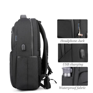 Black backpack with side headphone jack pocket and visible USB charging port