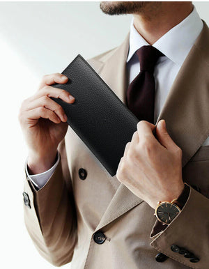 Black leather long wallet held in hand, slim profile with front logo