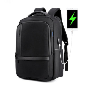 Black backpack with front zip pocket and USB charging cable connected to a tablet.