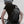 Black waterproof crossbody sling bag worn on back with adjustable strap and front zip