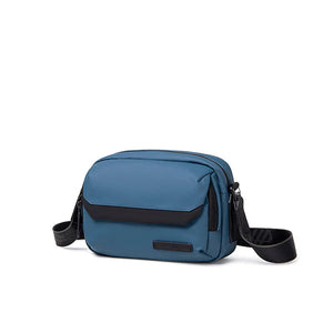 Blue waterproof crossbody bag with flap front, zip top, and adjustable shoulder strap