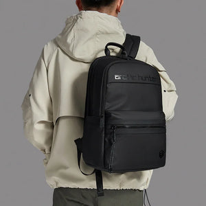 Person wearing a black backpack with 'arctic hunter' branding on a gray background
