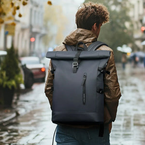 Dark roll-top waterproof travel backpack with padded straps and front buckle