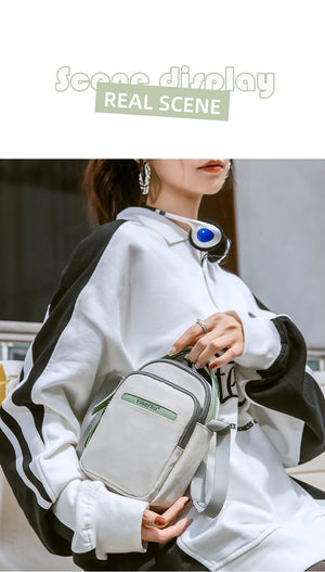 Waterproof crossbody bag in light gray with green trim and shoulder strap