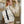 Beige compact commuter backpack with front flap, buckle straps, and side straps