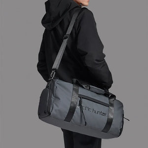 Waterproof duffel bag in dark grey with front logo panel and crossbody strap