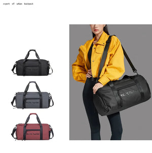 Waterproof duffel bag in black, grey, and red with shoulder strap shown on person