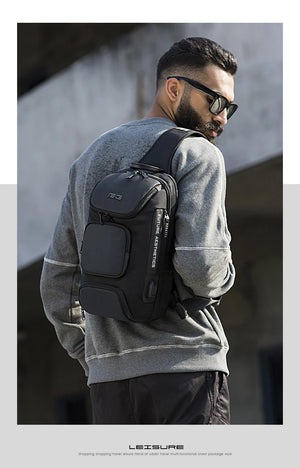 Dark grey crossbody sling bag on model, showing side profile and front pocket.