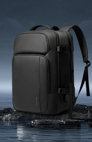 Black waterproof travel backpack with curved front panel, buckle strap, and top carry handle.