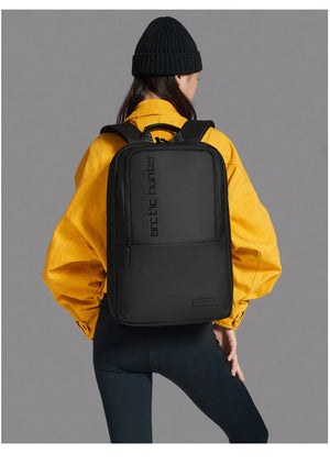Black waterproof travel backpack with padded straps and front zip panel