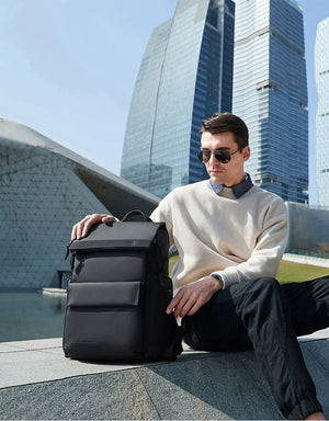 Large black waterproof travel backpack with front organizer pocket and top handle
