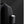 Black backpack with zippered side pocket holding a cylindrical bottle