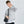 Black compact messenger bag worn with front zip pocket and adjustable strap