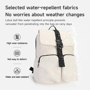 Light beige commuter backpack with front flap and zipper pocket, shown with water droplets