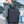 Black compact backpack worn by a man in a city setting