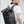 Black roll-top waterproof backpack worn from the side with orange zipper pull and cap.