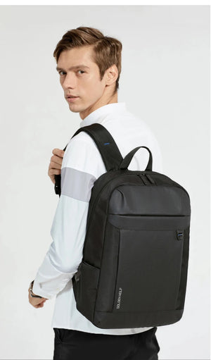 Man wearing a black travel backpack with front pocket and adjustable shoulder straps