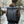 Dark roll-top waterproof travel backpack worn on back with buckle front strap