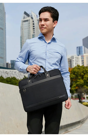 Black laptop tote bag with top handles and adjustable shoulder strap