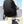 Black waterproof travel backpack worn by a model, with adjustable shoulder straps and side straps