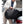 Black waterproof business backpack being placed on a car trunk, side straps and front bag visible.