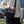 Black compact cross-body bag worn across the shoulder with adjustable strap