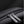 Close-up of smooth zipper and metal zipper pull on black textured backpack