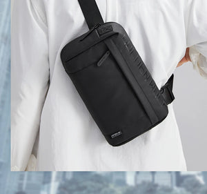 Black crossbody bag with front zip pocket and textured side panel details