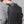 Black travel backpack worn on back with front straps and side adjustment buckle