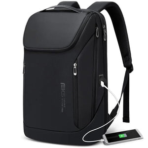 Black waterproof travel backpack with front zipper pockets and visible USB charging cable