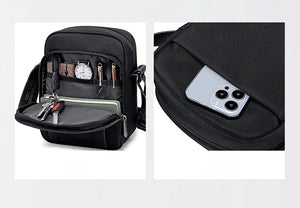 Black messenger bag with front organizer pocket; phone-sized slot visible on side