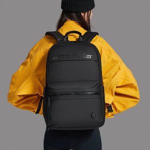 Person wearing a black backpack with 'arctic hunter' branding on a gray background