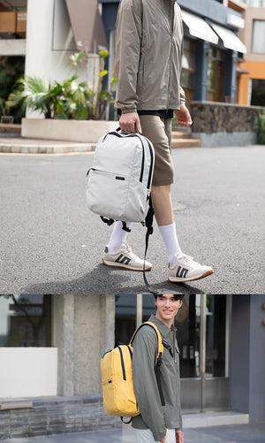 Compact laptop backpack worn outdoors with zippered front pocket and adjustable straps