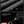 Black waterproof-look crossbody bag fabric close-up with textured surface.