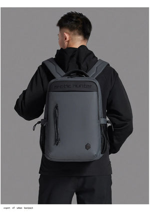 Black waterproof travel backpack worn on back with top handle and side straps